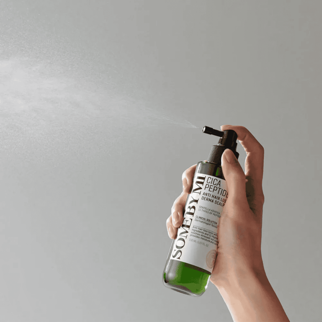 Nærbillede af en hånden, der bruger en sprayflaske med hudplejeprodukt til behandling af tør eller irriteret hud, ideel til almindelig og følsom hud.